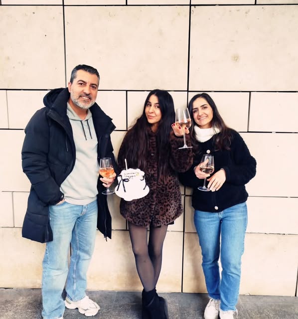 Three people holding glasses